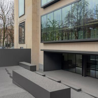 Area esterna della sede Sella con gradoni e panche in cemento davanti a grandi vetrate.