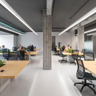 Vista esterna della sede Sella con facciata in pietra e grandi vetrate.